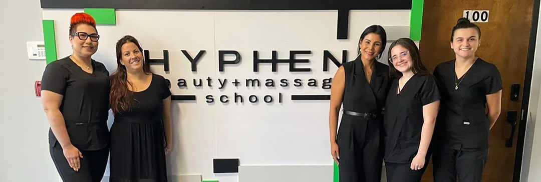 Hyphen team in front of the school sign at Hyphen Beauty + Massage School in Winter Park, FL