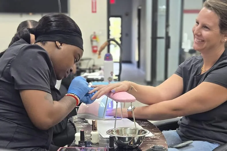 Nail tech student giving a manicure